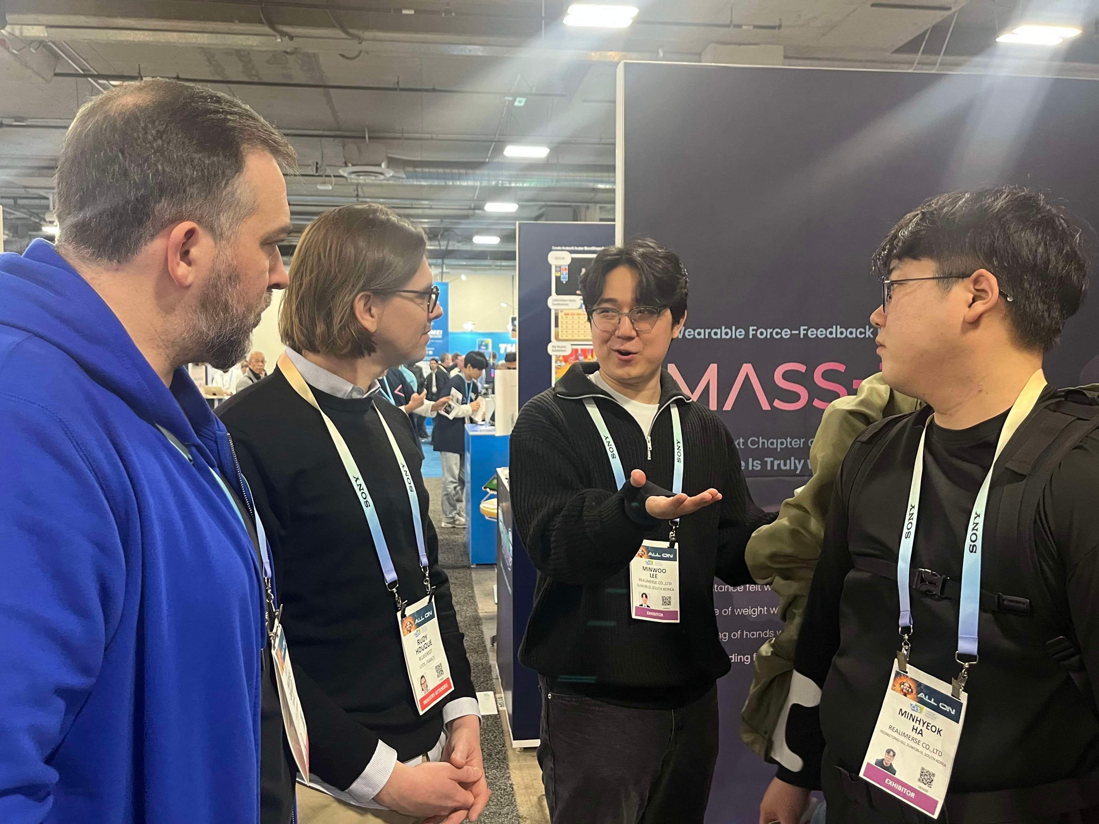 Minwoo discussing a wearable force-feedback project with attendees at a trade show booth